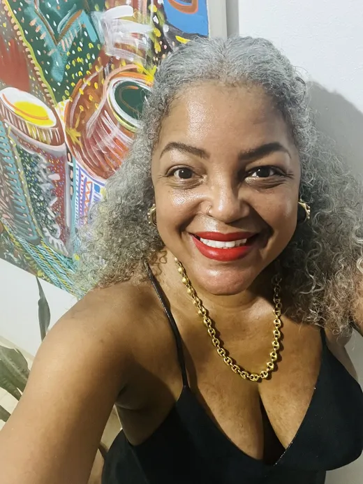 Tami Dee García smiling, wearing a gold chain